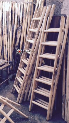 several wooden ladders leaning against a wall