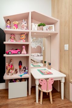 a doll house with pink furniture and toys on the shelves in front of it,