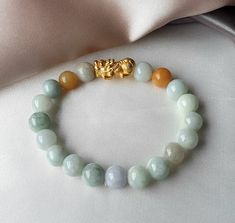 Feicui Jade Jadeite with S999 Silver Gold-Plated Pixiu Bracelet  Bead Size: 7.5mm to 8.5mm (approx) Pixiu Size: L17.5 x W9 x H8mm (approx)  ✅ All stones are unique and may vary from the one shown in the picture  Feicui bead colour tone will be selected at random from our stock. Please kindly do note & to accept before any purchase.  Jade is a protective stone that attracts Good Luck, Prosperity, Wealth & Health.  Pixiu is one of the most popular Feng Shui celestial animals that is believed to attract wealth, luck, windfall or direct income to the owner.   ❣ All items will be properly bubbled wrapped before mailing.   ❣ Our crystals and gemstones are 100% natural hence there may be natural flaws and slight blemishes on them.  Any irregularities (lines, different color shades etc.) should be Celestial Animals, Blue Tiger Eye Stone, Pixiu Bracelet, How To Clean Silver, Bracelet Bead, Blue Tigers Eye, Be Natural, Tiger Eye Stone, Crystals And Gemstones