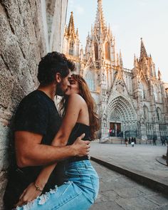 a man and woman sitting next to each other on the ground in front of a building