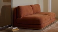 a brown couch sitting next to a window in a living room