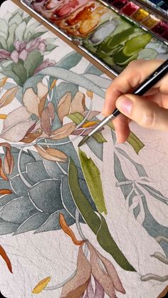 a person is painting flowers with watercolors