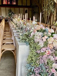 a long table with flowers and candles on it