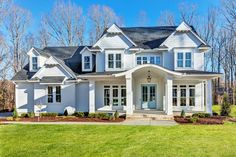 a large white house with lots of windows on it's front porch and landscaping