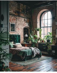 a bedroom with brick walls and lots of plants in the corner, along with a green velvet bed