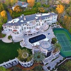 an aerial view of a mansion with a tennis court