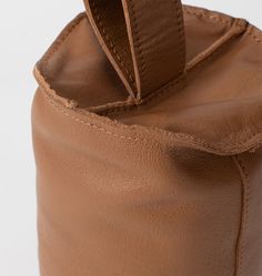 the inside of a brown leather bag with an attached strap and zippered closures