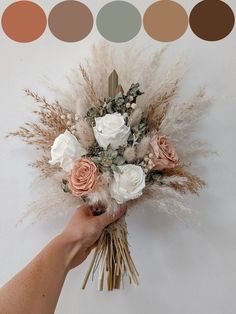 a person holding a bouquet of flowers in front of a white wall with color swatches