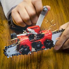 a person holding a pair of scissors over a red and black robot