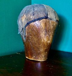 a wooden object sitting on top of a table next to a blue wall and wood floor