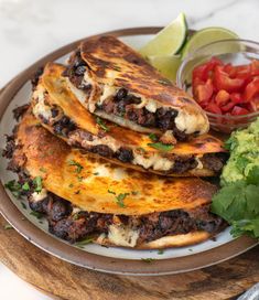 three quesadillas stacked on top of each other with salsa and avocado