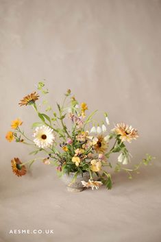 a vase filled with lots of flowers on top of a table