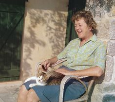 a woman sitting in a chair with a cat on her lap