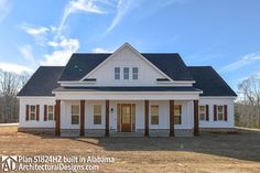 a large white house sitting on top of a dirt field