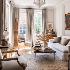 a living room filled with white furniture and lots of window sill space next to a painting on the wall