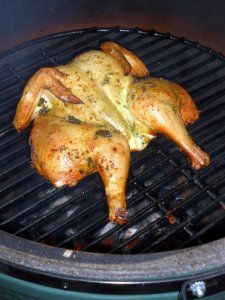 a chicken is cooking on the grill with it's legs spread out to dry