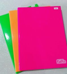 three neon colored notebooks sitting next to each other