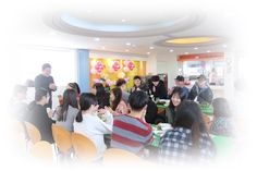 a group of people sitting at tables in a room with balloons hanging from the ceiling