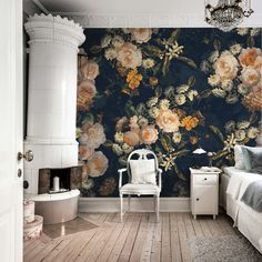 a bedroom with floral wallpaper and a white chair in front of the bed,