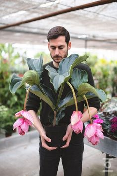 a man is holding some flowers in his hands