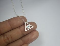 "A Triangle necklace, featuring the evil eye protection charm curved on a sterling silver chain. The classic \"protection from evil\" talisman, that can be an ideal accessory for the casual appearance and can be combined with other symbol jewelry to create a unique style. Let it be your lucky charm! A Classic and elegant Silver All seeing eye necklace This impressive piece Triangle Evil Eye Necklace would make a great mother gift .two sisters present, gift for daughter,friendship gifts for best Evil Eye Talisman, Silver Evil Eye Jewelry Gift, Symbolic Sterling Silver Evil Eye Jewelry, Symbolic Eye-shaped Silver Jewelry, Evil Eye Symbolic Metal Jewelry, Sterling Silver Evil Eye Jewelry For Gifts, Symbolic Evil Eye Metal Jewelry, Spiritual Sterling Silver Evil Eye Charm Necklaces, Symbolic Evil Eye Charm Necklace For Gift