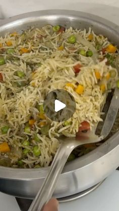 a pan filled with rice and vegetables on top of a stove