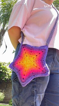 a woman is holding a crocheted bag in the shape of a star,