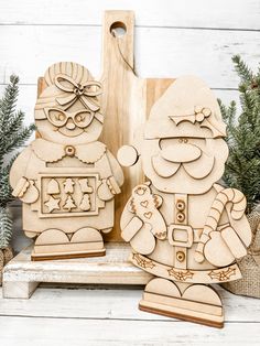 two wooden christmas decorations sitting next to each other