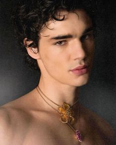 a shirtless young man wearing a necklace with flowers on it's collarline