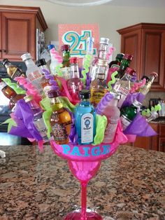 a vase filled with lots of bottles on top of a counter