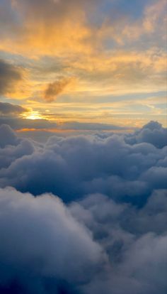 the sky is filled with clouds as the sun sets in the distance behind it,