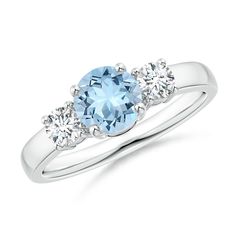 a three stone ring with an aqua blue topazte and two diamonds on the side