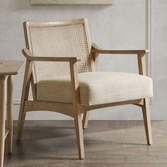 a wooden chair sitting next to a table on top of a hard wood floor in front of a white wall