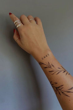 a woman's hand with a small tattoo on her left wrist and the word love written in cursive writing