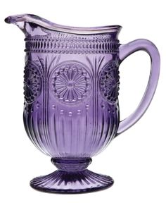 a purple glass pitcher sitting on top of a table