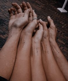 four people with their hands on top of each other