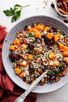 a bowl filled with rice, carrots and nuts