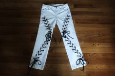 White and black lace up jeans, size Medium. ❤️DESCRIPTION: Reworked white jeans.  100% recycled.  Brilliant white jeans with grommets and lace up detail on both legs.  Lots of visual interest.  Perfect for your streetwear look! ❤️MEASUREMENTS: * size 10 Medium * 29 inch waist * 28 inch inseam * 100% recycled cotton, poly laces ❤️SHIPPING:  Immediate shipping worldwide; buy with confidence. ❤️MY SHOP: Click this link to see all the items in my shop:  www.TatteredEden.etsy.com Click this link to s Edgy Fitted White Jeans, Edgy White Fitted Jeans, White Edgy Jeans For Spring, Edgy White Jeans For Spring, Edgy White Denim Bottoms, Lace Up Jeans, Thigh High Leg Warmers, Work Sweaters, Belted Mini Skirt