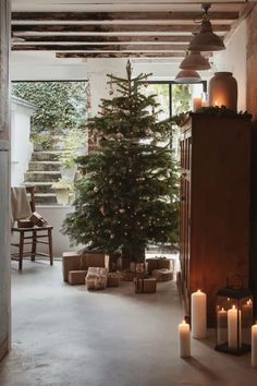 a living room with candles and a christmas tree