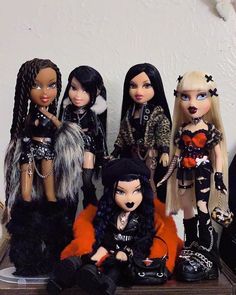 several dolls are sitting on a shelf together