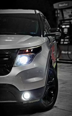 the front end of a white suv parked in a parking lot