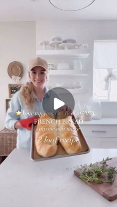 a woman holding a tray with bread on it