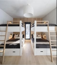 there are bunk beds in the room with ladders