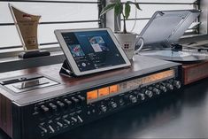 an electronic device sitting on top of a table next to a record player and turntable