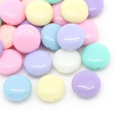 pastel colored candy balls are scattered on a white surface