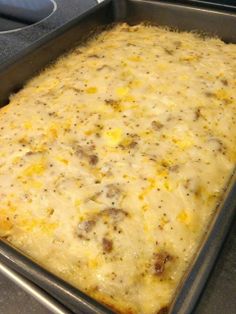 a casserole dish with cheese and sausage in it