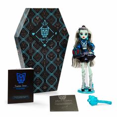 a doll is standing next to a box and keychain with a skull on it