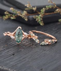 a close up of a ring on a wooden surface with flowers and leaves around it