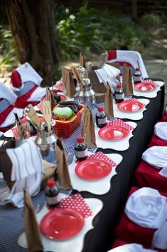 a table set up with red and white plates, napkins, and paper bags