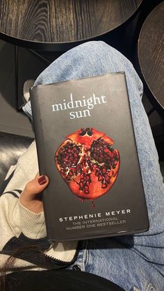 the book midnight sun is sitting on someone's lap